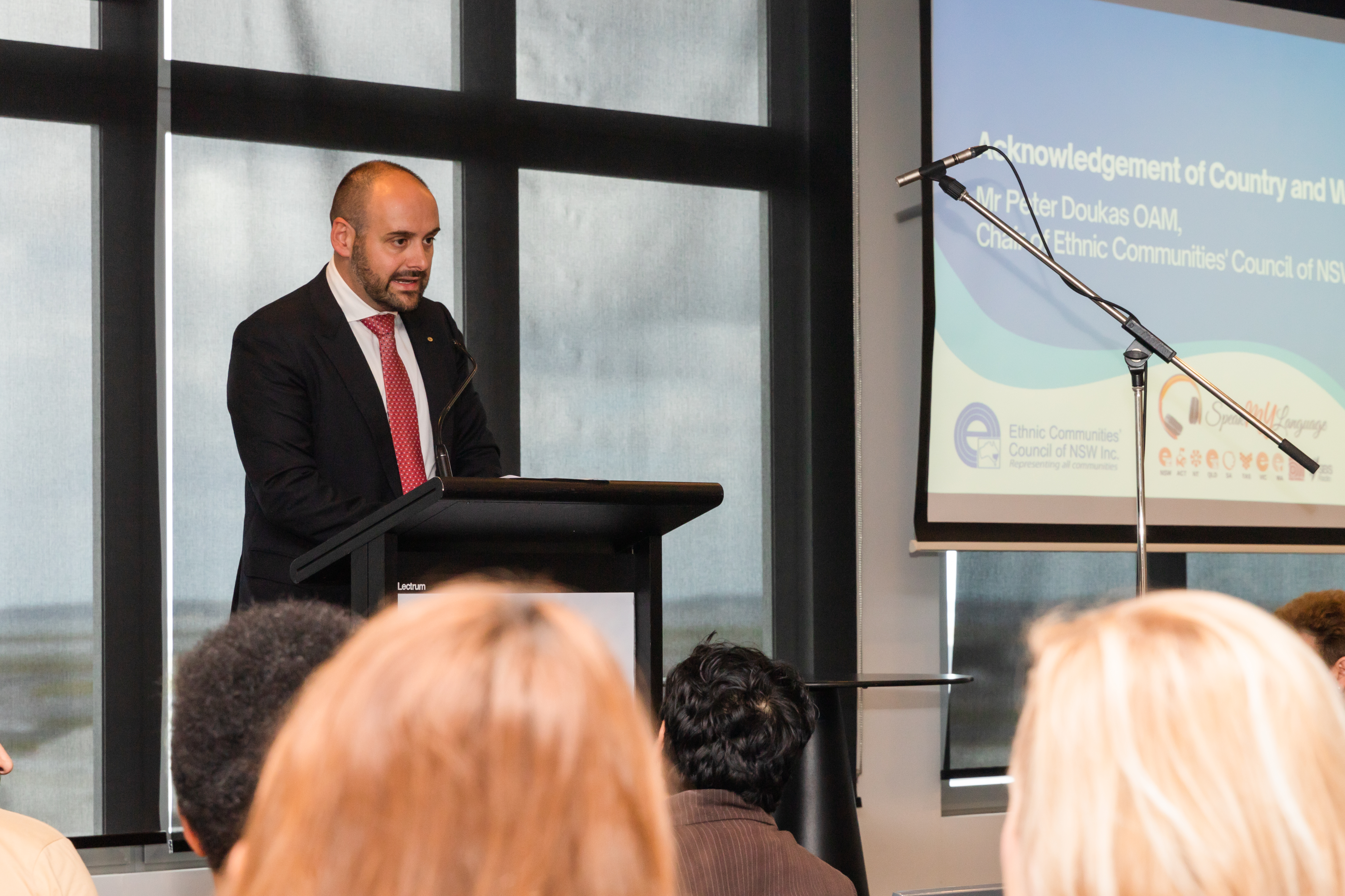 Peter Doukas OAM speaking at podium