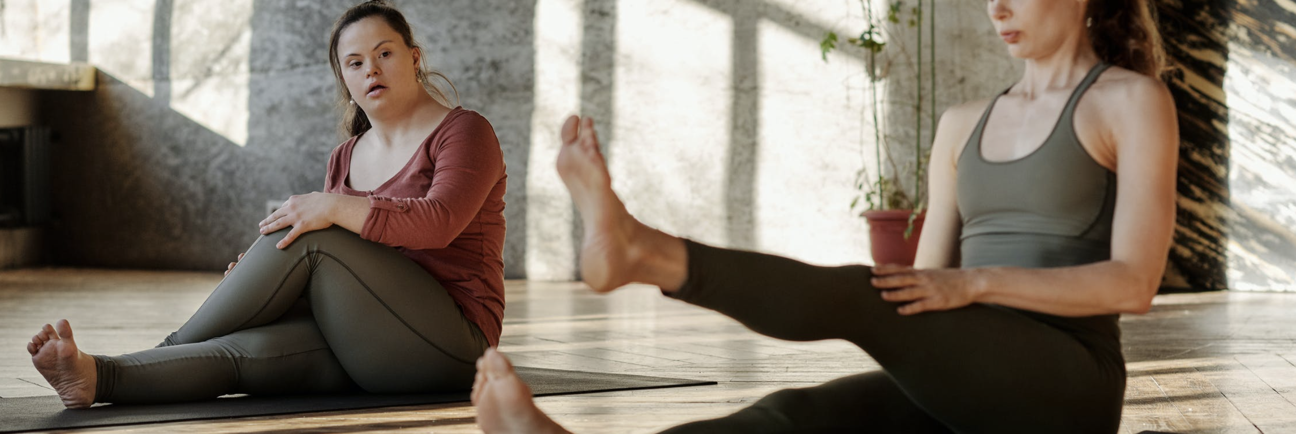Two girls do yoga, one who has Down syndrome