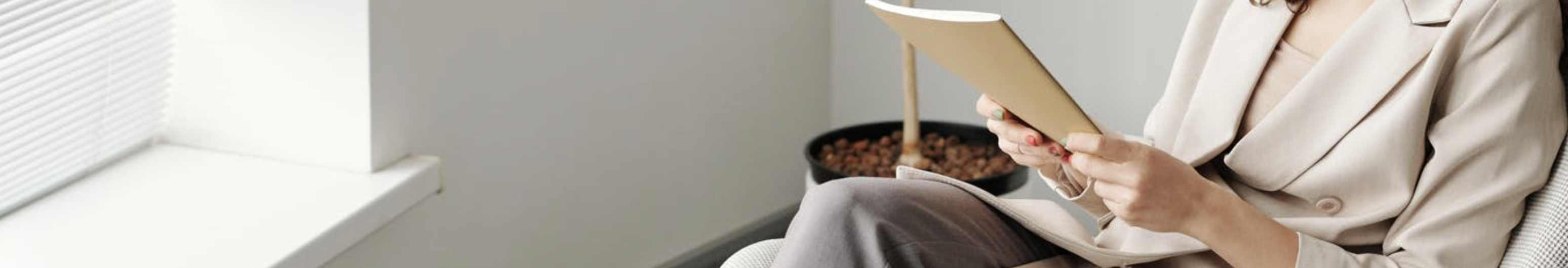 A cropped, close up image of a counsellor holding her notebook